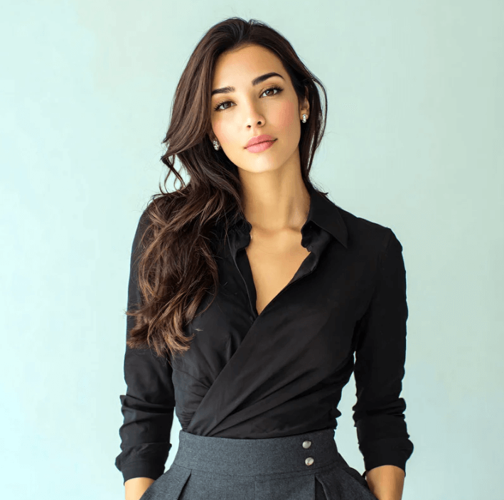 Woman in a black blouse with long hair against a light blue background, showcasing natural beauty and elegance.