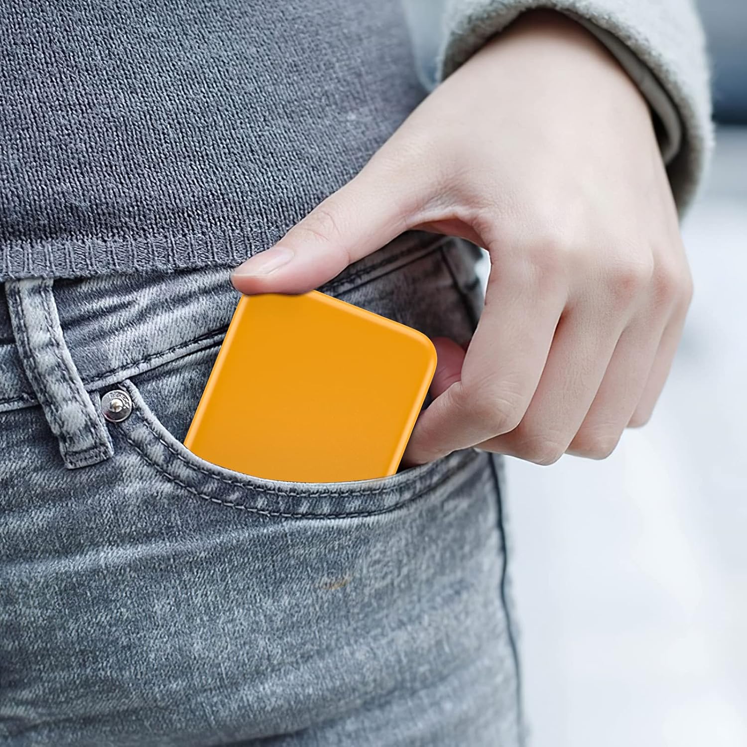 Person placing Quivy GlowPocket Mirror in pocket for easy access and convenient beauty touch-ups.